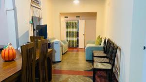 a living room with chairs and a couch and a television at The Old Manor - Weligama in Weligama