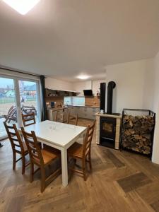 a kitchen with a table and chairs and a stove at Chalupa Postřekovo in Postřekov
