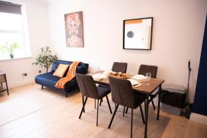 a living room with a table and a blue couch at Sleeps 6- Close to the beach - Pet Friendly in Brighton & Hove