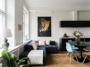a living room with a blue couch and a painting of a tiger at Luxurious Inner-City Flat in Malmö