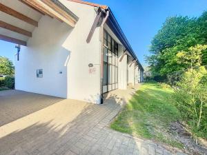 a white building with a walkway next to it at Maison Seayah - Westende in Middelkerke