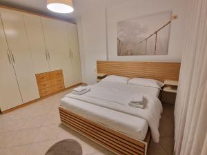 ein Schlafzimmer mit einem großen Bett mit weißer Bettwäsche in der Unterkunft Beachfront Apartment in Sarandë