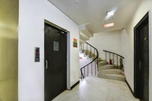 un pasillo con una puerta negra y escaleras en Hotel Sweet Home Lodge - 2 min from New Delhi Railway Station, en Nueva Delhi