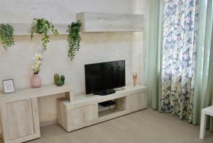a living room with a flat screen tv on a cabinet at Casa tua a Pergusa in Pergusa
