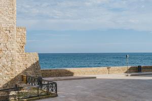 una pared de piedra con el océano en el fondo en Sea View Romantic Apartments Al Vecchio Porto, en Monopoli 40 fotos más
