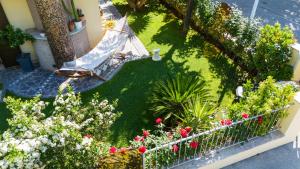 米萨诺阿德里亚蒂科Le Rose - Suites e Breakfast a 5 min dal mare e Misano World Circuit的带吊床和鲜花的花园的鸟瞰图