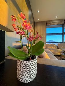 eine Vase mit Blumen auf einem Tisch im Schlafzimmer in der Unterkunft Luxury Family Beachfront Apartment in Las Palmas de Gran Canaria
