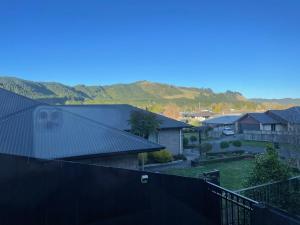 a view of a house with mountains in the background at Cute Stylish 2 bed Rooms in Rotorua