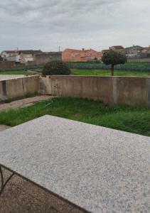 a concrete table in a yard with a wall at Flamant apart in Aguçadoura
