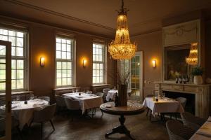 a dining room with tables and chairs and a chandelier at Landgoed Altenbroek in Voeren +31 photos