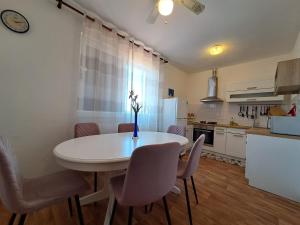 a kitchen with a white table and chairs in a room at Holiday House Piacun in Sućuraj +45 photos