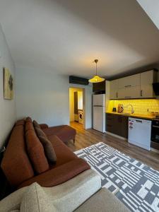 a living room with a couch and a kitchen at Ergül Motel in Kucukkuyu