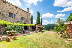 an external view of a stone house with a yard at Casa Gialla a Murlo in Murlo