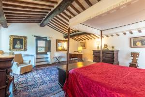 a bedroom with a bed with a red bedspread at Casa Gialla a Murlo in Murlo