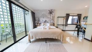 カロンビーチにあるMitsu Guesthouseのベッドと大きな窓のある寝室
