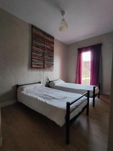 two beds in a room with a window at Centro Ecoturismo Barbatona Sigüenza in Barbatona