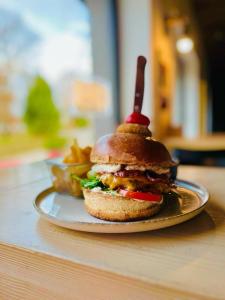 ein Sandwich auf einem Teller mit Pommes frites auf einem Tisch in der Unterkunft Ludwig Hotel in Martonvásár + 51 Fotos