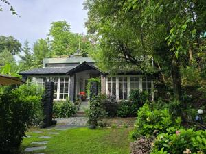 a small house with a garden in front of it at The Owls Nest Farm in Dharmsala