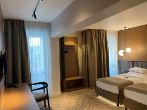 a hotel room with two beds and a table at Grand Hotel Coroana in Bistriţa