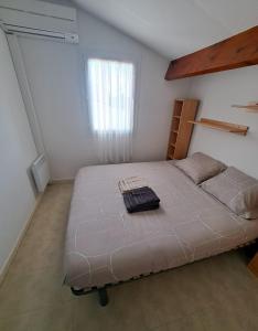 a bedroom with a large bed in a room at Mas provençal T4 climatisé avec parking et jardinet in Aigues-Mortes