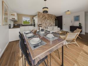 a dining room and living room with a table and chairs at Maison neuve avec terrasse et jardin pour 6 in Beg-Meil +14 photos