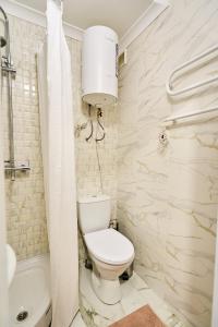 a bathroom with a toilet and a sink and a tub at Botanical garden and Airport Studio Combo in Chişinău