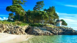 a lighthouse on the shore of a beach at Maison neuve avec terrasse et jardin pour 6 in Beg-Meil