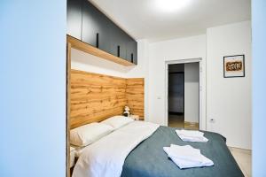 a bedroom with a large bed with a wooden headboard at Botanical garden and Airport Studio Combo in Chişinău
