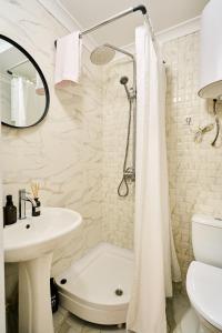 a white bathroom with a sink and a shower at Botanical garden and Airport Studio Combo in Chişinău