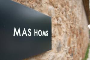 a sign that says mass homes on a stone wall at Casa Rural Mas Homs in Parets de Dalt