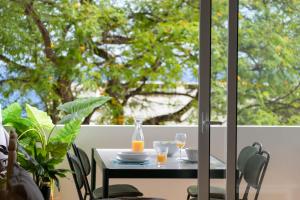 a table with two glasses of orange juice on a balcony at Lido II by An Island Apart in Funchal +15 photos