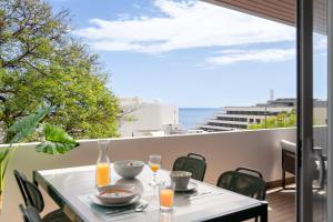 a table on a balcony with a view of the ocean at Lido II by An Island Apart in Funchal