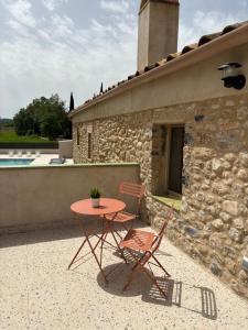 a table and two chairs sitting next to a building at Casa Rural Mas Homs in Parets de Dalt