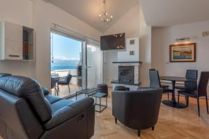 a living room with a couch and a table at APARTMENTS BRUNO 1&2 - two-room penthouse apartments - wonderful panoramic view of the sea - the best location, first row to the beach - 10 minutes from Supetar ferry port - free secured parking - facilities nearby in Sutivan