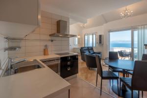 a kitchen and dining room with a table and chairs at APARTMENTS BRUNO 1&2 - two-room penthouse apartments - wonderful panoramic view of the sea - the best location, first row to the beach - 10 minutes from Supetar ferry port - free secured parking - facilities nearby in Sutivan