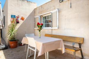 a white table with a vase of flowers and a window at Casa 2 Hermanas Formentera in Illes Balears