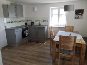 Una cocina con una mesa, un fregadero y una estufa. en Ferienwohnung Beim Schuster, en Hitzleried