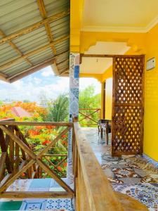 a balcony of a house with a view of a garden at COCCOBELLO AFRICAN Village- in Nungwi
