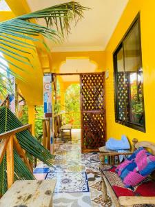 a living room with yellow walls and a patio at COCCOBELLO AFRICAN Village- in Nungwi