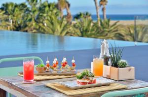 a table with two plates of food and drinks at INNSiDE by Meliá Fuerteventura – Adults Only in Costa Calma