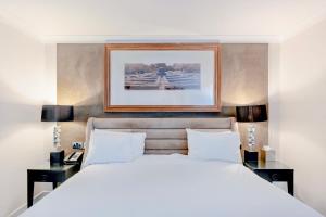 a bedroom with a white bed and two night stands at The Landmark Hotel and SPA Leisure Club Dundee By Sunday in Dundee
