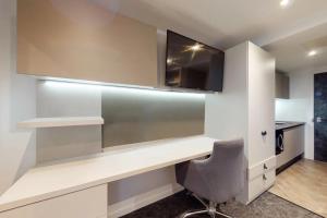 una habitación con un escritorio con televisión y una silla en Canvas Manchester, en Mánchester