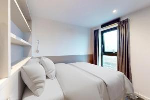 Una cama blanca en una habitación con ventana. en Canvas Manchester, en Mánchester 50 fotos más