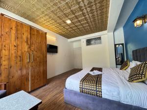 Un dormitorio con una cama grande con techo de madera. en Royal Link Way near by Pizza Hut Maal Road 1km, en Manali