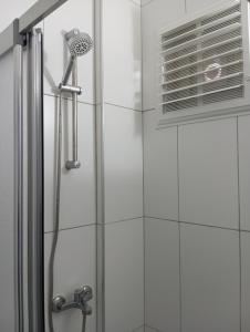 a shower with a glass door and a shower coil at Gökçeada Helios Pansiyon in Gokceada Town