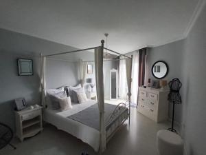 a bedroom with a canopy bed and a mirror at Rincón del Mar Terrazas y vistas a la Ría de Vigo in Moaña