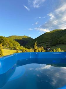 a pool of water with mountains in the background at Rustic Cottage in Sibiu