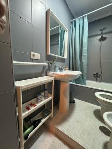 ein Badezimmer mit Waschbecken, Toilette und Spiegel in der Unterkunft Una Parada en el Camino 3 in Fisterra