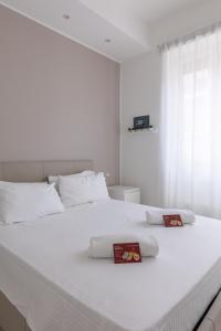 a white bed with two towels on top of it at Via Santa Croce 1 in Milan