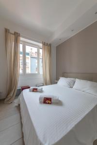 a bedroom with a large white bed with two towels on it at Via Santa Croce 1 in Milan